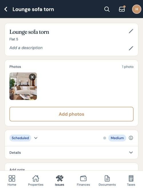 A maintenance issue for Flat 5, a torn lounge sofa, open on a phone with its photograph and its status set to scheduled.